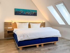 a bedroom with a large bed with a blue frame at Tordalk 09 in Prerow