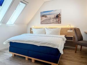 a bedroom with a bed and a desk and a chair at Tordalk 09 in Prerow +9 photos