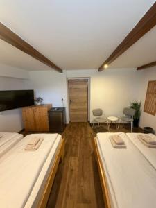 a room with two beds and a hallway with chairs at Vila Eva Lesce - Bled in Lesce