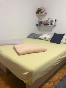 a large yellow bed in a room with toys on a shelf at Nevade home in Gornji Milanovac