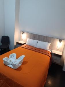 a bedroom with a bed with an orange bedspread at HOTEL BOUTIQUE TerrazaINN in Arequipa