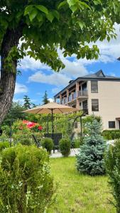 a park with an umbrella and a building at Villa Ikalto in Telavi