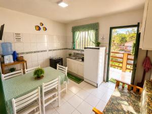 a kitchen with a table and a refrigerator at Solar das Andorinhas Pousada in Itapoa