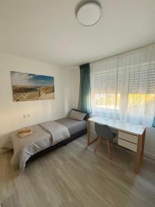 a bedroom with a bed and a desk and a desk at AG Apartments Waiblingen in Waldmühle