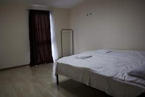 a bedroom with a white bed and a window at Villatun in Stepʼanavan