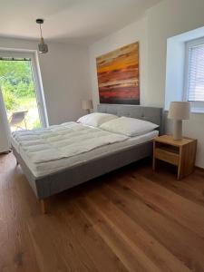a large bed in a room with a large window at Refugium Mitterbach in Mitterbach