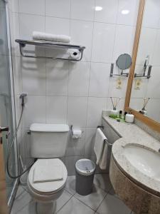 a bathroom with a toilet and a sink at Guarulhos Flat Hotel in Guarulhos +8 photos