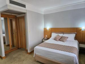 a bedroom with a large bed in a hotel room at Guarulhos Flat Hotel in Guarulhos