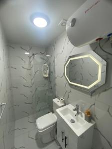 a bathroom with a toilet and a sink and a mirror at Pateriku Apartments in Shkodër +38 photos