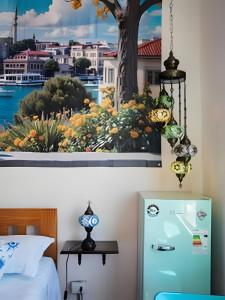a bedroom with a blue refrigerator in front of a window at Casa Fran Valparaíso | Vive un Hotel Temático in Valparaíso