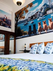 a bedroom with a bed with a picture of cats on the wall at Casa Fran Valparaíso | Vive un Hotel Temático in Valparaíso