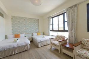 una camera d'albergo con due letti e un divano di Xiang Xiang a Città Vecchia di Hengchun