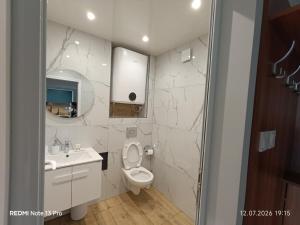 a bathroom with a toilet and a sink and a mirror at SEA VIEW FLORA in Burgas +33 photos