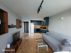 a living room with a couch and a kitchen at SEA VIEW FLORA in Burgas