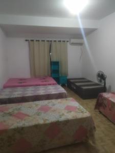 ein Schlafzimmer mit zwei Betten und einer Deckenleuchte in der Unterkunft Ebora Afro economy in Ilhéus