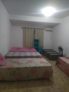 ein Schlafzimmer mit zwei Betten in einem Zimmer in der Unterkunft Ebora Afro economy in Ilhéus