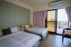 a hotel room with two beds and a balcony at Xiang Xiang in Hengchun