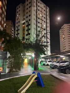 a slide on the grass in a city at night at Apto amplo e confortável in Aracaju