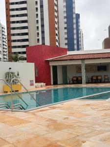 a swimming pool in a city with tall buildings at Apto amplo e confortável in Aracaju