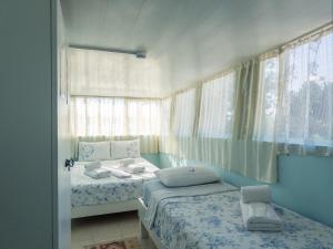 a bedroom with two beds and a window at Tarihi Rum Konağı Antikhan in Ayvalık