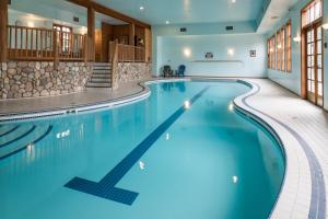 a swimming pool in a hotel with blue water at Glacier House Hotel & Resort in Revelstoke