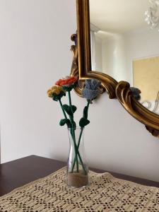 a vase with flowers in front of a mirror at Holy family in Pachino