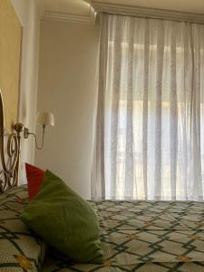a bedroom with a window and a bed with a green pillow at Holy family in Pachino