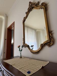 a mirror on a wall next to a table with flowers at Holy family in Pachino +21 photos