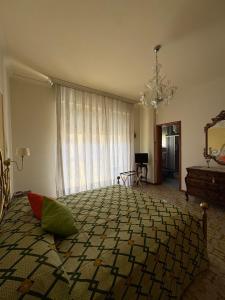 a bedroom with a large bed and a chandelier at Holy family in Pachino