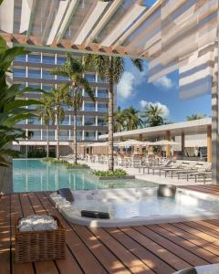 a swimming pool with a hot tub on a deck with a building at Beach GAV Resort in Salinópolis