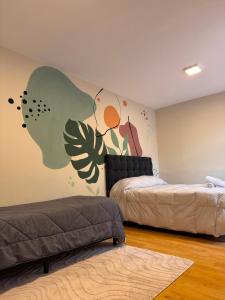 a bedroom with two beds and a mural on the wall at Mendoza Centro Apartment in Mendoza