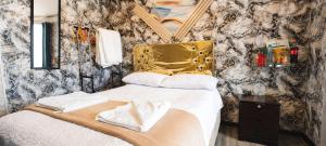 a bedroom with a bed with a gold headboard and a mirror at Concubinas del Inca in Cajamarca