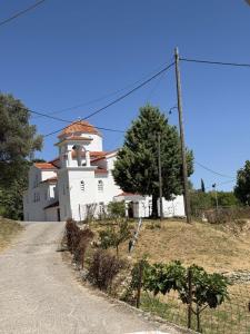 a white building with a tower on top of a hill at Male home in Maletiánoi