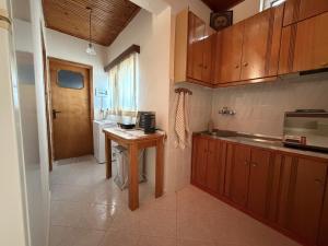 a kitchen with wooden cabinets and a table in it at Male home in Maletiánoi