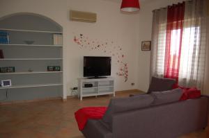 een woonkamer met een bank en een flatscreen-tv bij Agrigento Doc House in Agrigento