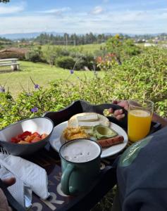 a table with a plate of food and a glass of orange juice at Vitta Glamping in Rionegro