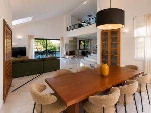 a dining room and living room with a wooden table and chairs at Gregorys Private Luxury Villa with Heated Pool & Gardens in SFakianalíon