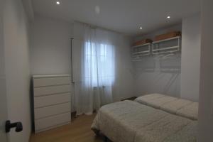 a bedroom with two beds and a dresser and a window at Fogar dos Americanos in Borneiro