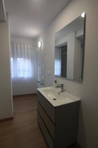 a bathroom with a sink and a mirror at Fogar dos Americanos in Borneiro +11 photos