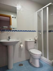 a bathroom with a toilet and a sink at Hostal El Poligono in Zamora