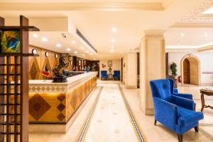 a lobby with a bar and a blue chair at St George Hotel - The Zoo in Cairo