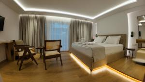 a bedroom with a bed and a table and a chair at Vila Kosteli in Himare