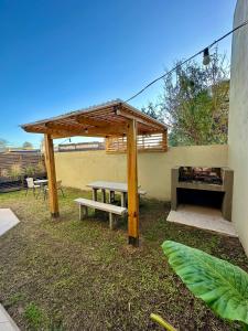 a picnic shelter with a bench and a picnic table at Lo de Marieta in San Antonio de Areco