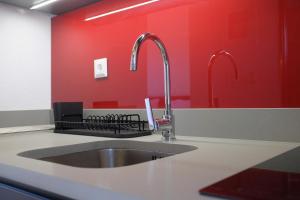 a kitchen with a sink and a red wall at Aeon Retreat in Rovies +17 photos