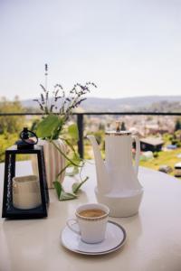 a table with a cup of coffee and a vase at Apartmány Saxana in Smržovka