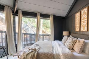 a bedroom with a bed and a large window at Breathtaking Boutique Treehouse nestled in clouds in Beech Mountain