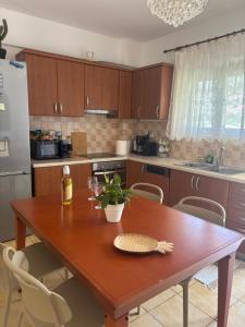 a kitchen with a wooden table with chairs and a refrigerator at Alexandra Villa in Bali