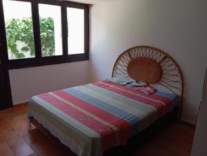a bedroom with a bed in a room with two windows at Maison de plage familiale à Cabo in Cabo Negro