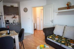 a living room with a couch and a kitchen at VukaNest apartman Jagodina in Jagodina