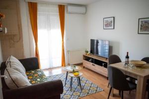 a living room with a couch and a tv at VukaNest apartman Jagodina in Jagodina